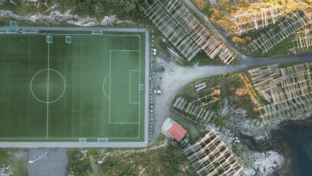 Aerial view of Lofoten's most famous soccer football field in Henningsvaer on an island with drying cod fish racks