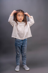 Happy girl wearing white shirt on gray background, Close-up portrait of smartkid nice-looking with questioning face wearing white shirt. 