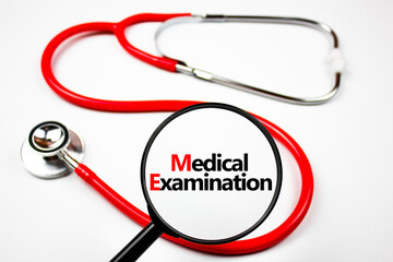 Medical examination concept. Medical examination text through a magnifying glass on the background...