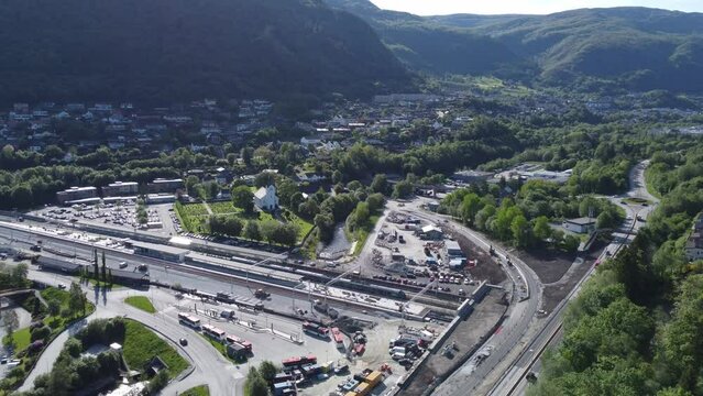 Arna train station and road E16 with dense populated lush green mountain landscape background - Sunny summer day aerial view outside Bergen Norway