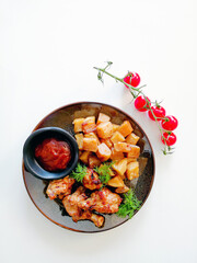 Chicken wings with sauce and golden French fries potatoes