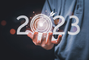 Business target and goal on New year 2023 concept, hand holding 2022 virtual screen. businessman...