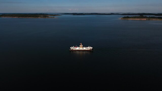 Aerial view away from a car ferry in the archipelago of Aland islands, Finland - pull back, drone shot