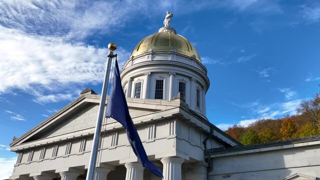 Vermont flag flying outside the State Capitol building. Close up of state emblem in Montpelier, VT.