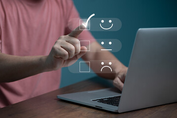 Customer service satisfaction concept ,Business people are touching the virtual screen on the happy Smiley face icon to give satisfaction in service. rating very impressed.
