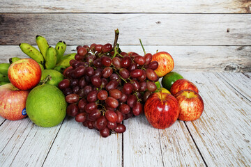 Various of fruits with Red grape, red apple and green orange on wooden background