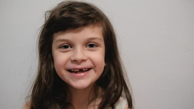 Happy smiling 6 years old little girl shows her milk teeth missing. Child laugh on dentists check up.