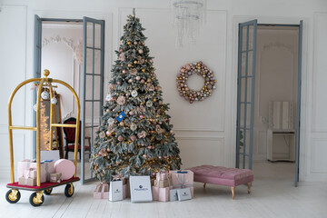 Christmas toys on a fir-tree close up with interior background of a luxury hotel apartment