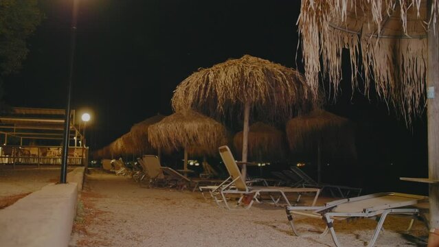 Beach with sunbeds and umbrellas at night, Moraitika beach