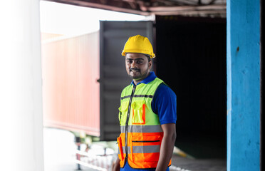 Portrait of Young warehouse worker working in factory warehouse storage, Worker man wearing hardhat and safety vest standing in the warehouse