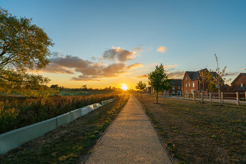 Fototapeta na wymiar Empty walkway path at sunset near new build housing area in southern England