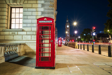 Red telephone booth and Big Ben at night in London. England