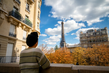 Holidays in Paris. Eiffel Tower in autumn season seen by female tourist - focus on the tower 