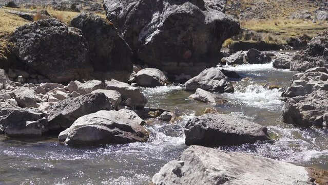 Rio peque&ntilde;o cruzando camino de piedras en un sendero de Sierra Peruana 