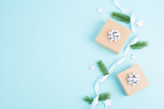 Christmas holiday greeting card with little gift boxes, stars and fir branches, blue background