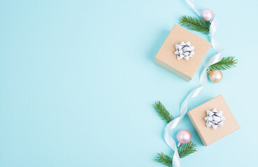 Christmas holiday greeting card with little gift boxes, baubles and fir branches, blue background
