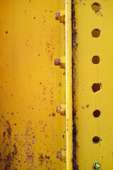 黄色いペンキの鉄板にビス　錆びや汚れ