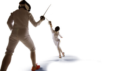 Two female fencing athletes fight isolated on white