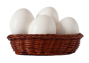 Group of fresh, raw white chicken eggs in mini brown wicker basket isolated on white background with selective focus.