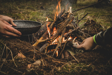 preparation of a pan, for cooking on a fire in the forest.