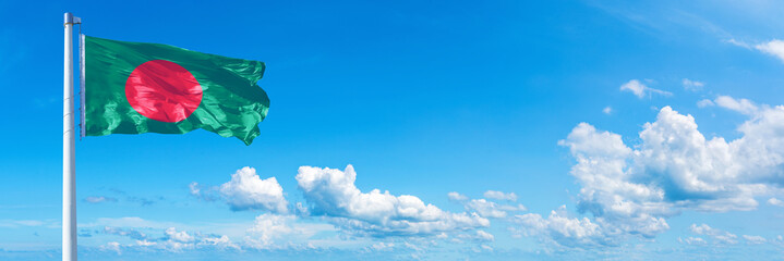 Bangladesh flag waving on a blue sky in beautiful clouds - Horizontal banner