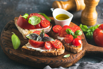 Tomato and ricotta bruschetta garnished with olive oil and basil