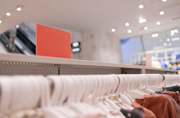 Close up clothes hangers on rack with anti theft alarm. Background for fashion retail shop shop and...