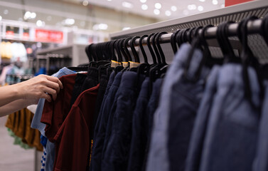Close up clothes hangers on rack with anti theft alarm. Background for fashion retail shop shop and...