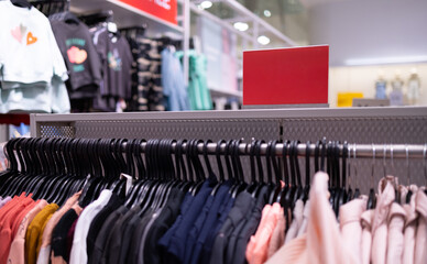 Close up clothes hangers on rack with anti theft alarm. Background for fashion retail shop shop and apparel store.