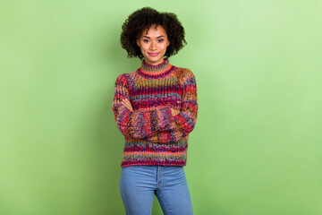 Portrait of pretty calm lady crossed arms look camera wear sweater isolated on green color background