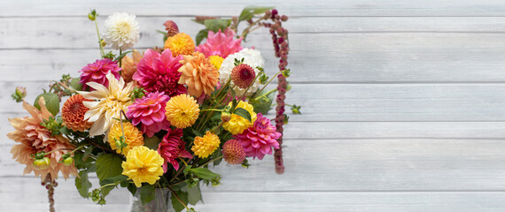  Kompozycja kwiatowa z kwiatów dalii, różowy bukiet na drewnianym tle jasnych desek