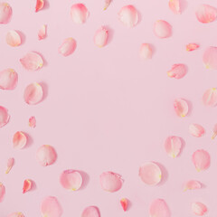 Pink rose petals round frame on bright pink background. Minimal romantic layout with copy space.