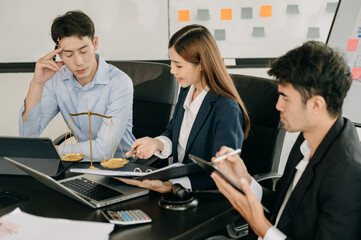 Asian business team and lawyers discussing contract papers sitting at the table. Concepts of law, advice, legal services. at office