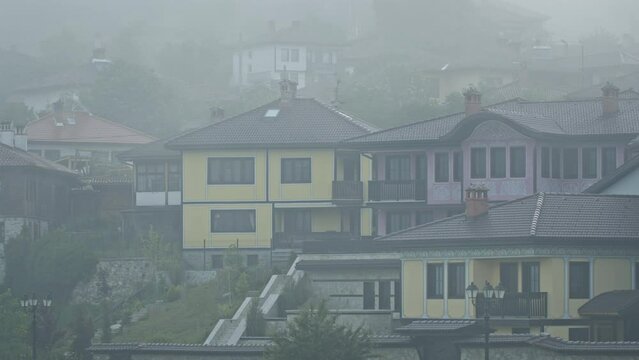 Establishing locked down shot of the historic town of Koprivshtitsa in Bulgaria under morning fog.