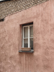 Window with wooden shutters, neutral pink wall. Traditional European old town building. Old ancient historic architecture