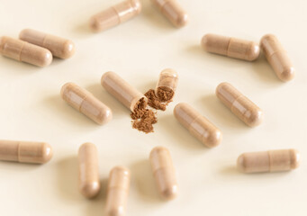 Opened Medical capsules on light beige close up. Taking dietary supplements