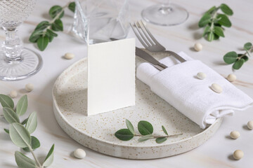 Table setting with folded card decorated with eucalyptus branches close up, Wedding mockup