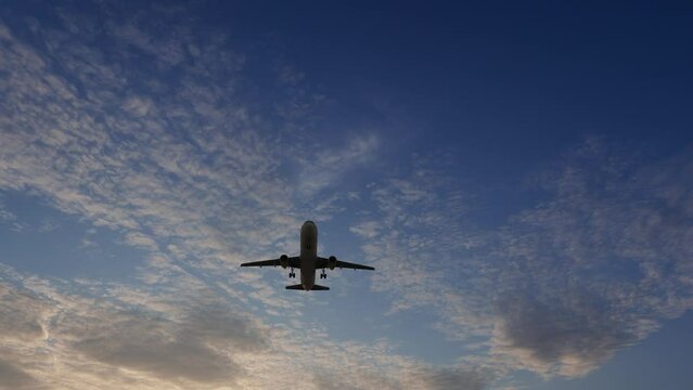 3840x2160. Ultra HD 4K. Airplane flies in sky at sunset day. Travel. Airplane takes off against the background of sunset. 
