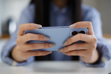 Gamer playing mobile games on smartphone. Young girl plays video game online with modern gadget