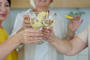 Friends clinking with glasses of wine. Three people clinking with glasses of white wine, celebrating success and speaking toast.