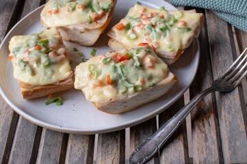 Grilled ham and cheese sandwich on french baguette with chives and bell peppers