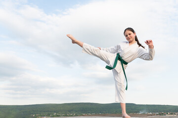 karate concept. teen girl practicing karate. girl karate fighter on sky background. copy space © be free