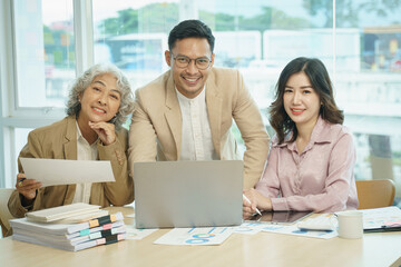 Group of Asia creative people in smart casual wear smiling in creative office workplace.Businesspeople colleague partnership or office coworker teamwork concept.