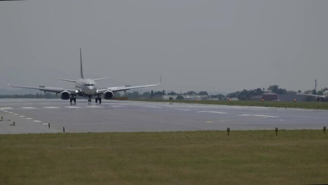 Passenger plane taxiing on airport runway before taking off, hot air distortion effects visible