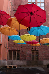 street colored umbrellas on the background of a brick wal