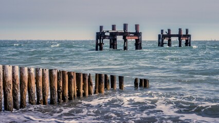 Beautiful view of an ocean with wooden groins at the Lepe Beach, Hampshire, United Kingdom