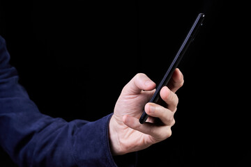 Man looking at smartphone screen on dark background