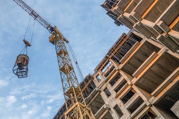 Low angle shot of a crane with equipment on a construction site with a new building infrastructure © Albert Karimov/Wirestock Creators