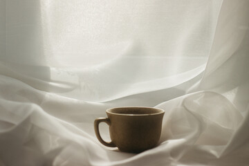 cup of coffee in the morning. espresso coffee. Coffee porridge on a white background
a cup of coffee on a white cloth. sun rays on a cup of coffee