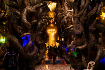 Buddha image statue and naga guardian of Wat Maniwong temple for thai people travel visit tunnel...